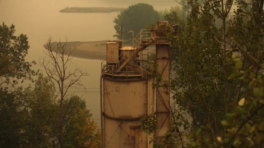 Industrial steel container outside besides trees and water