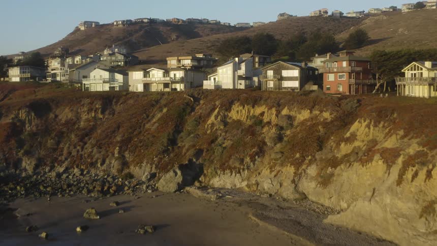 Aerial view of a small residential complex on the cliffs of a beach at morning