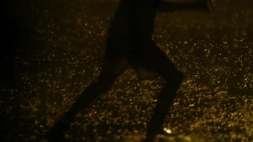 Children play soccer at night in the rain