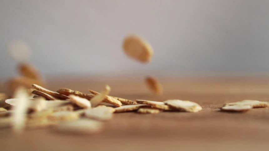Dried pumpkin seeds falling over a wooden table