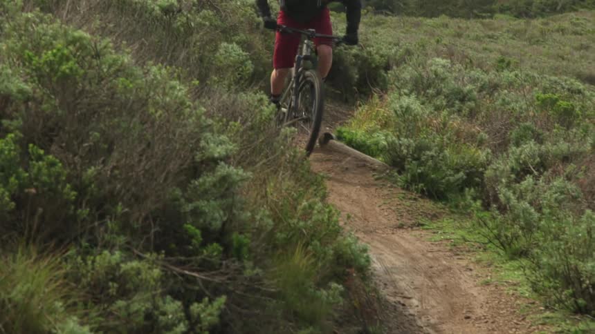 Man drives a cross country mountain bike uphill on a dirt road