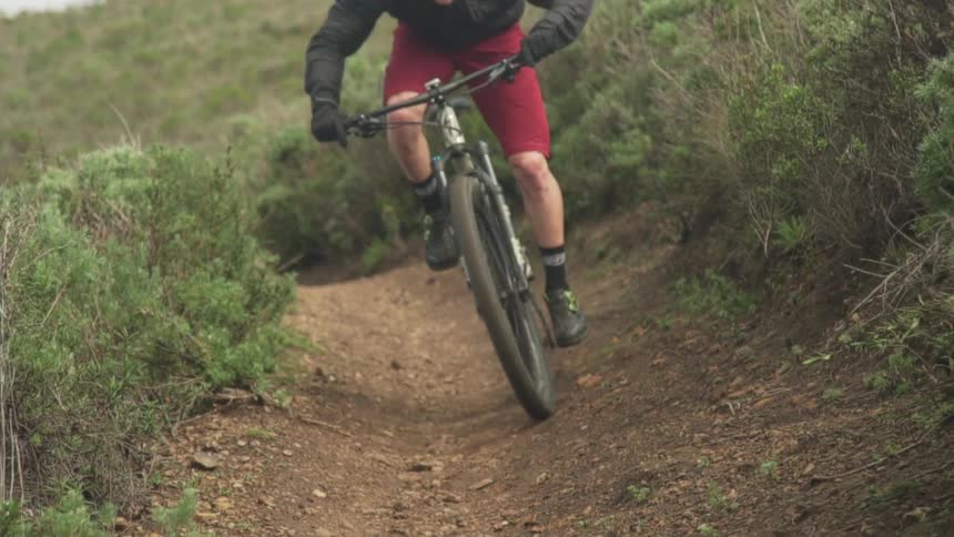 A man mountain bikes down a hill