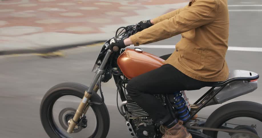 A man rides a motorcycle through a city streets