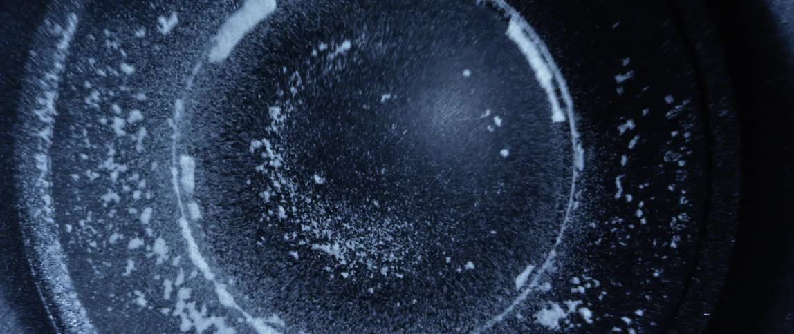 White grains of dust jumping over a vibrating speaker