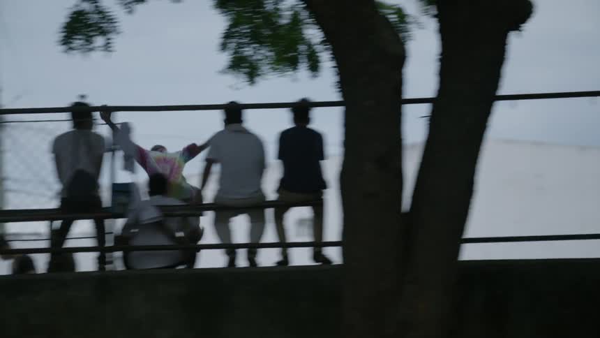 People are in a park one is doing jumps on a skateboard