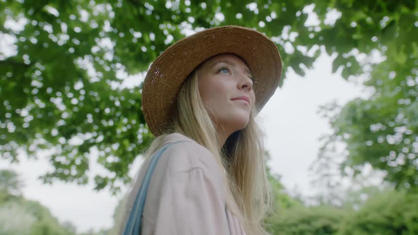 A blonde woman stands and admires her surroundings outdoors