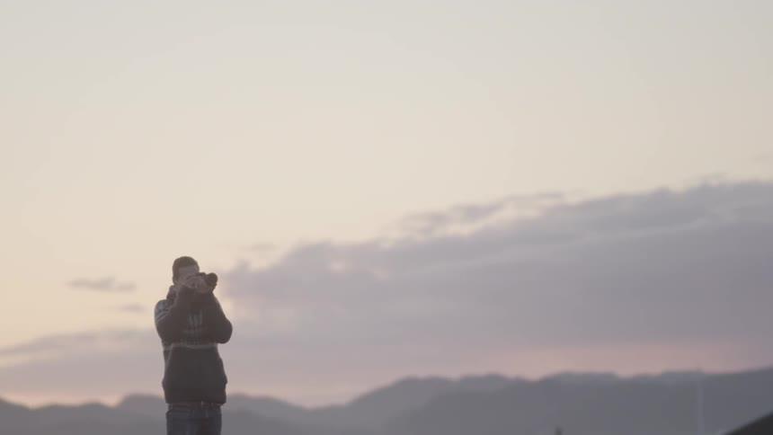 Man taking a photograph on a cloudy day