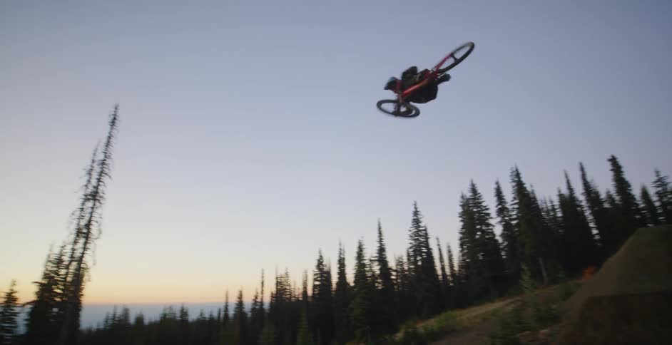 A person jumps off an outdoor ramp and does a trick on a bike