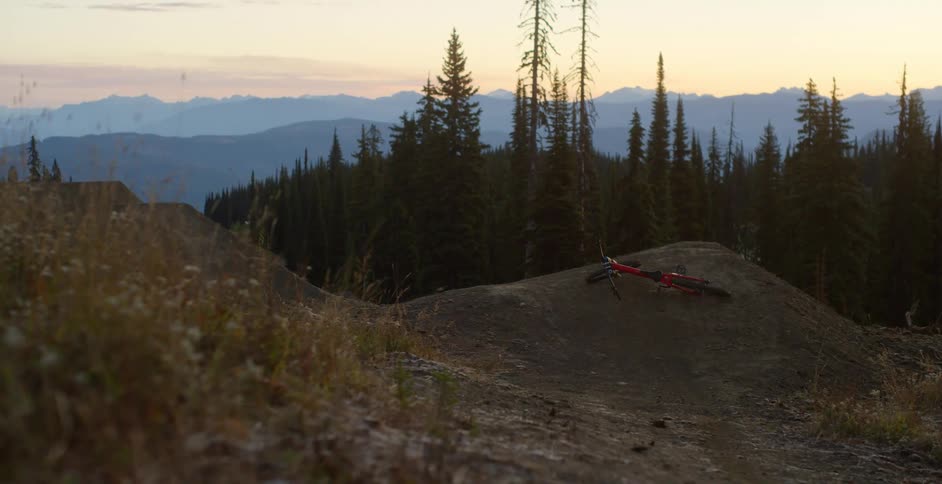 Red cross country mountain bike laying in a mound atop of a mountain