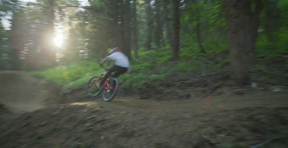 A man is dirt biking through a forest