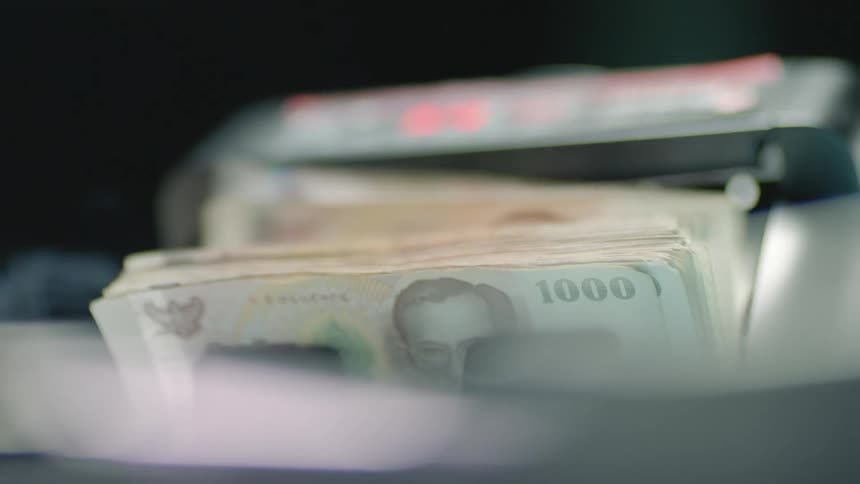 A person using a machine to count money