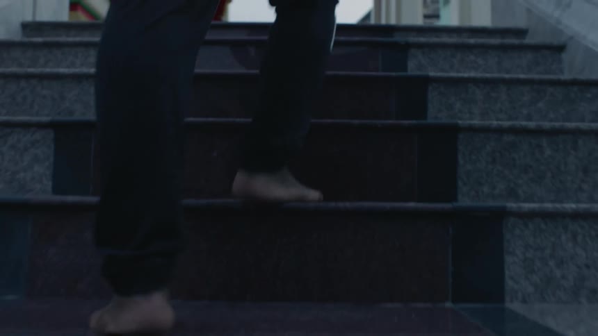 A man is walking up a flight of stairs outdoors