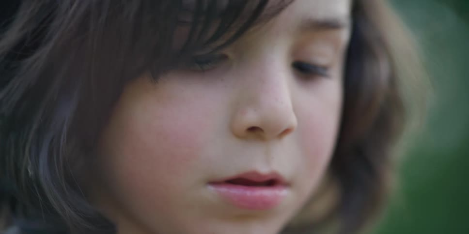 A young boy looks around outside