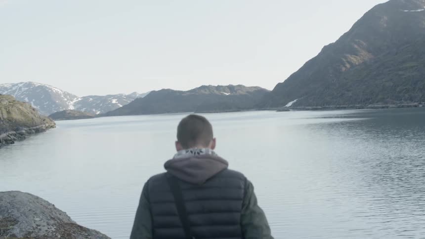 Man walking down a path towards a river