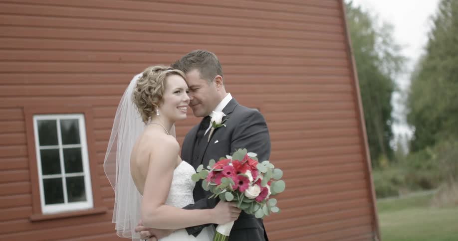 A bride and groom embrace outside