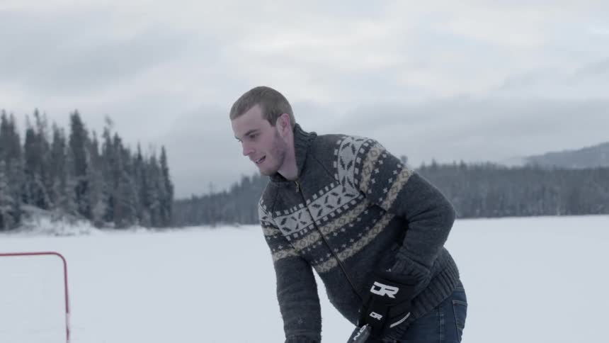 A man is playing hockey on a ice covered area
