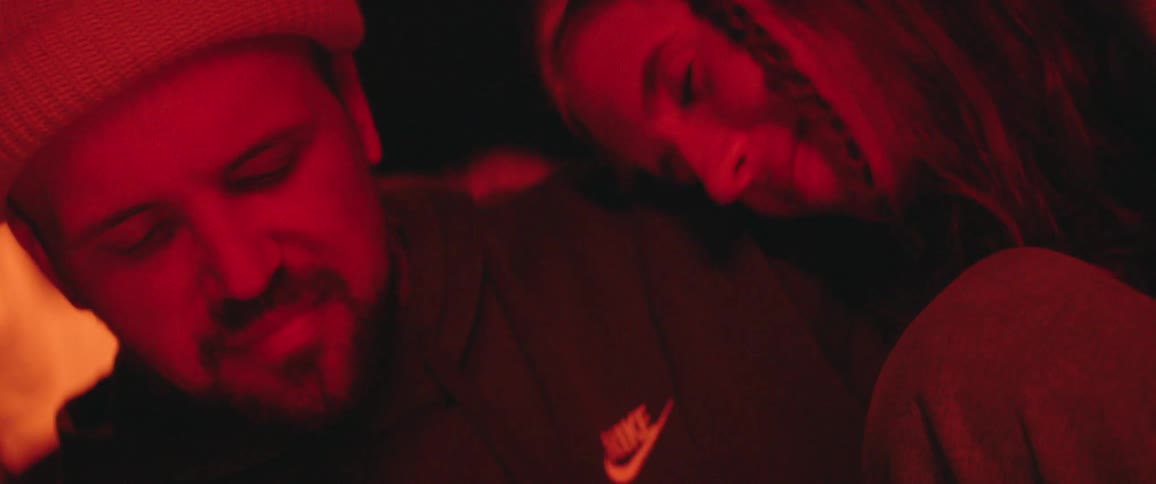 A woman and man are outdoors at night