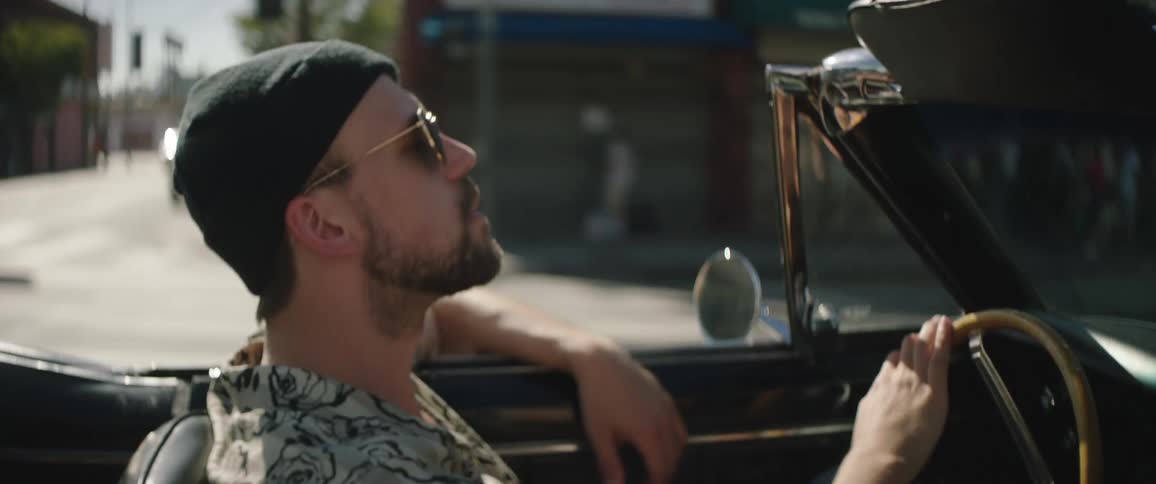 Man driving down a street in downtown la in a vintage vehicle at daytime