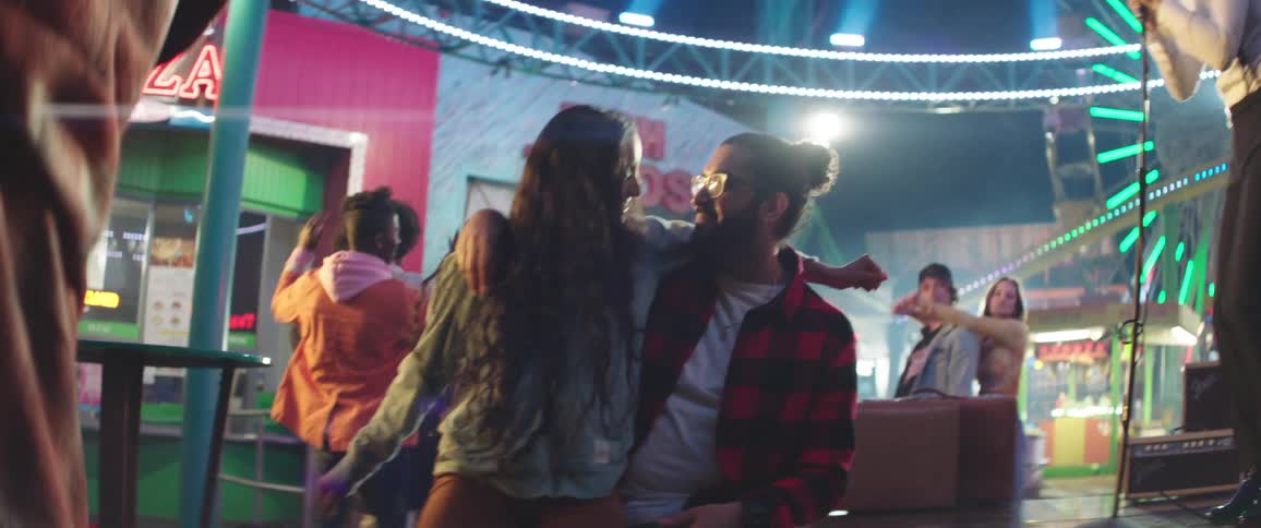 A group of people dance as they listen to a woman sing at a club
