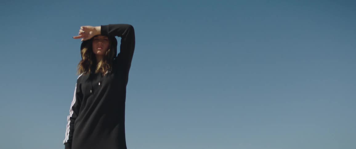 A woman is standing outdoors during the day