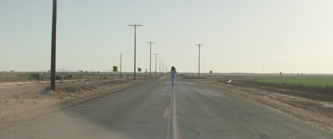 A woman is running outdoors in a rural area