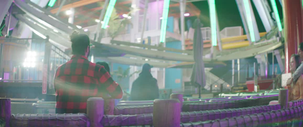 Two young couples happily walk towards a ferris wheel ride