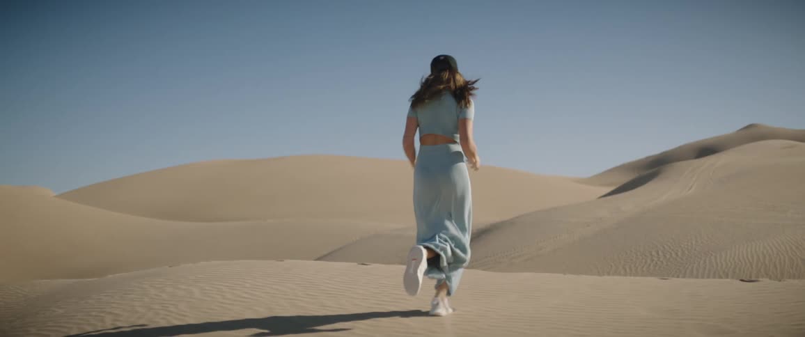 A young woman running across the desert