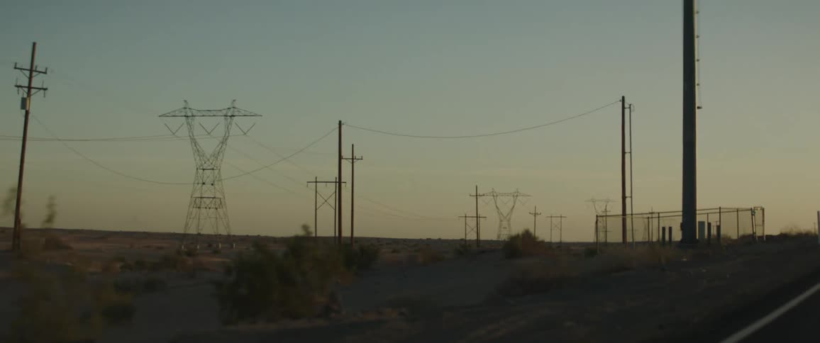 Power lines out in a desert in the evening time