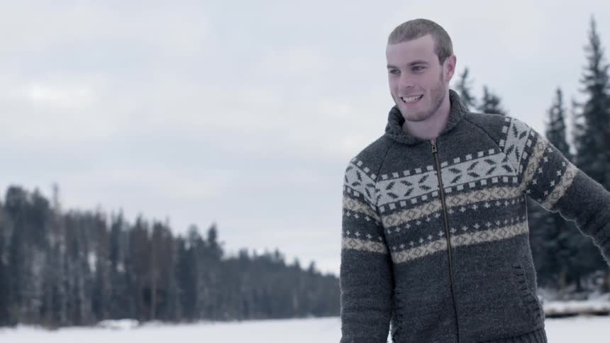 A man is smiling as he stands out on a snow covered area