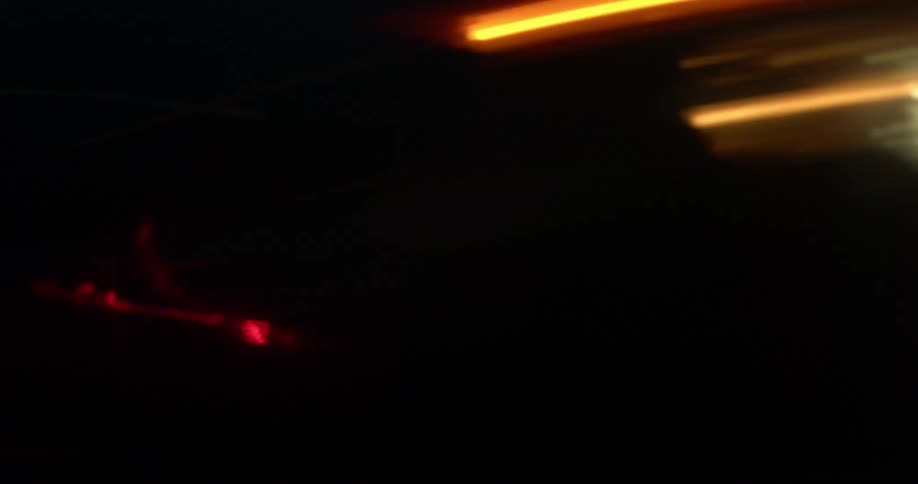 Vehicle speeds by on plain near mountain in streaks of light