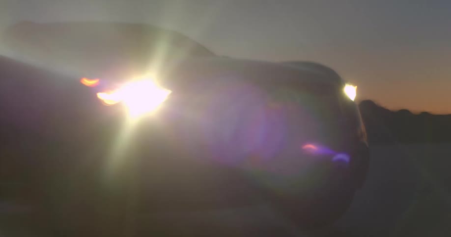 A sport utility vehicle drives haphazardly through a desert at night