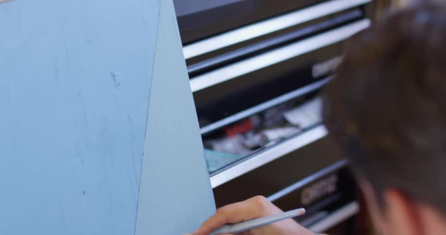 A man is painting with a small brush