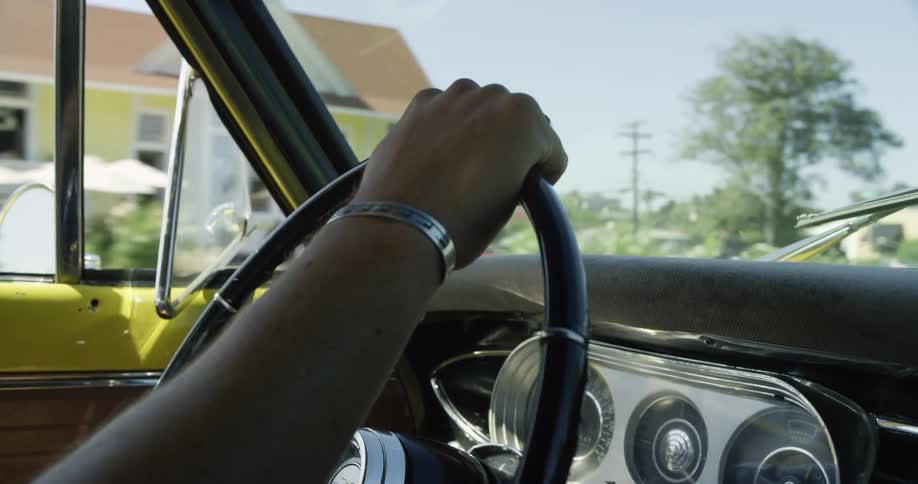 A person is driving a car through a neighborhood