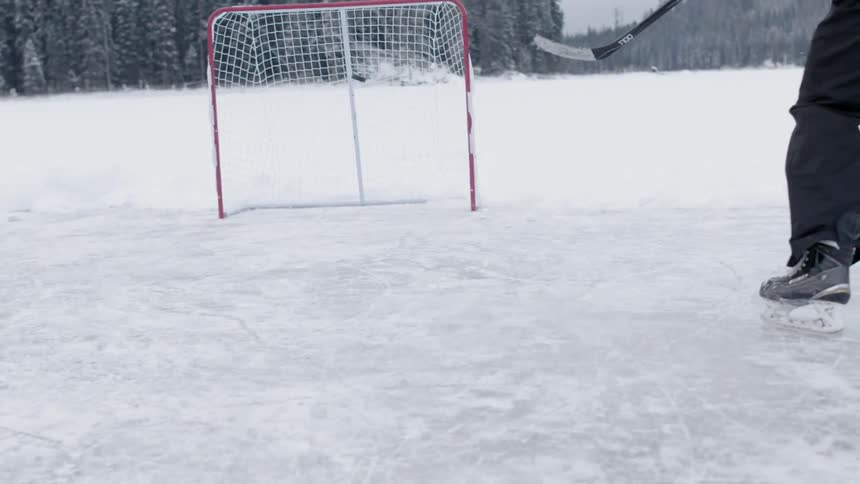 A man playing ice hockey on a frozen lake