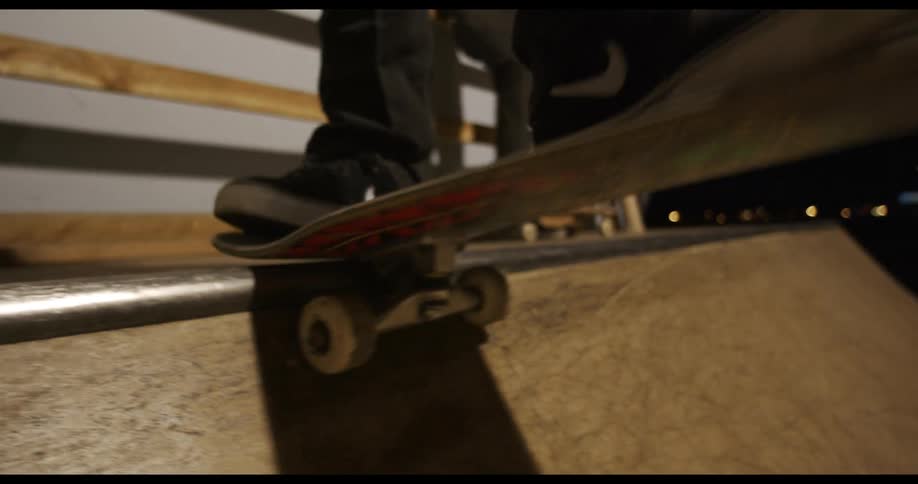 People ride skateboards at skate park at night