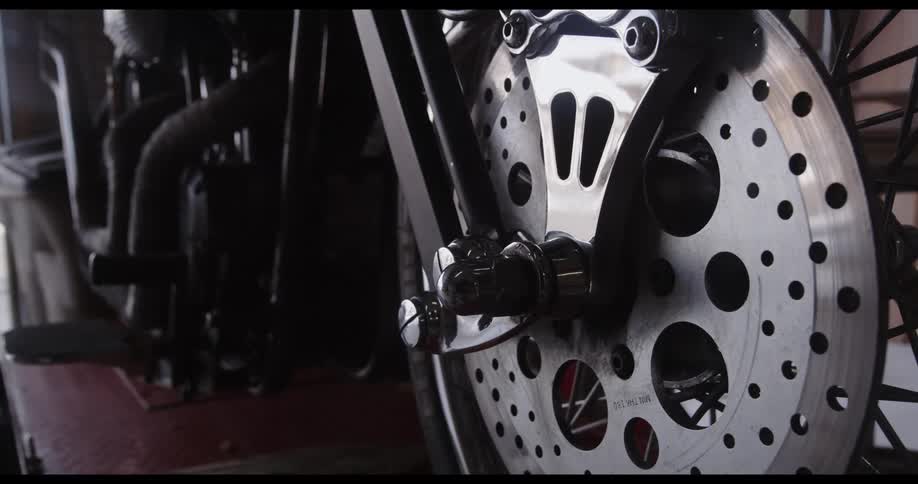 A close up of the break disc of a motorcycle reveals some wear