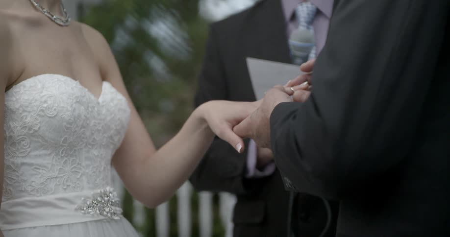 A man puts a ring on his new wife's finger