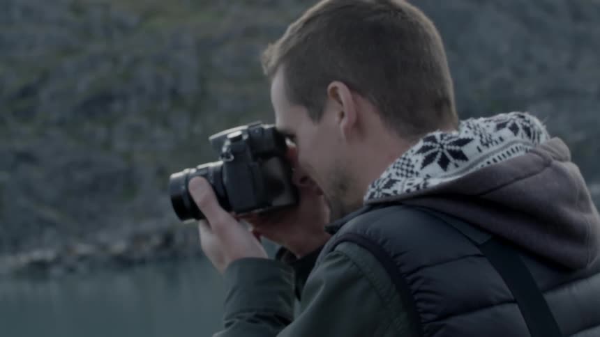 Man takes a photograph outside in the wild