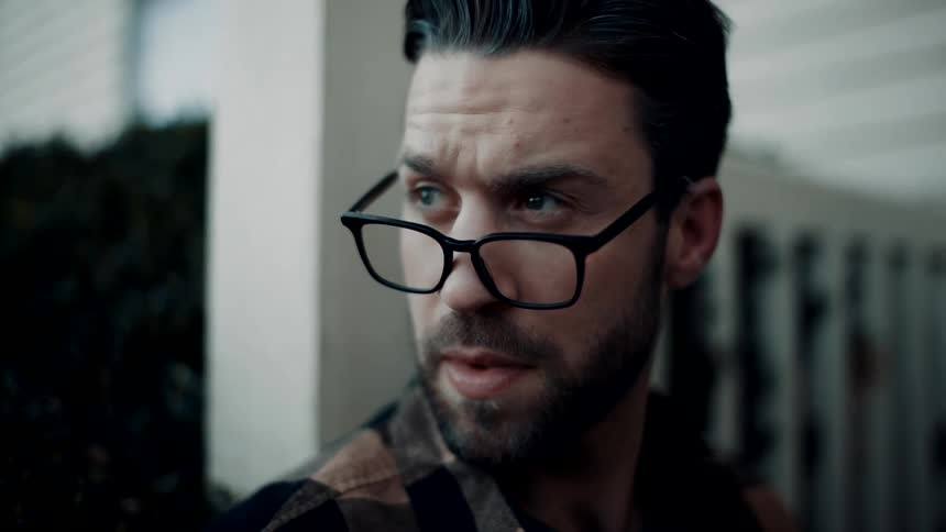 A bearded man wearing glasses looks around while taking inventory of this surroundings
