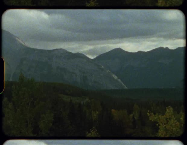 Film of the forests near a tall mountain range in an overcast day
