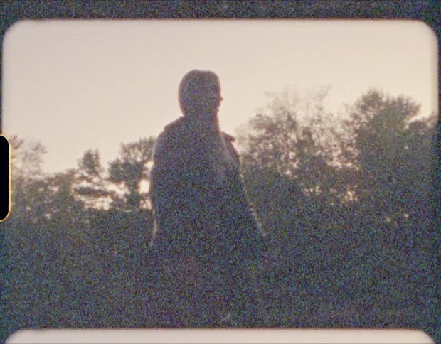 An old film strip of a girl skipping rocks in a river