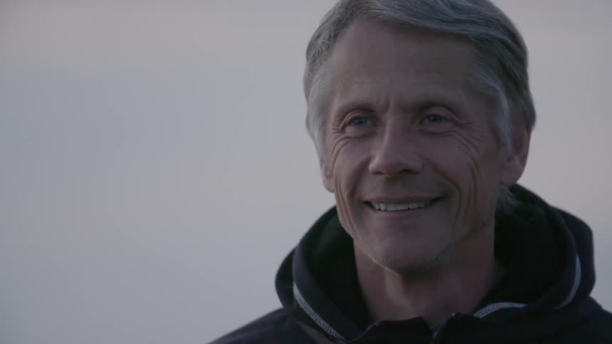 A man is smiling on a cloudy day