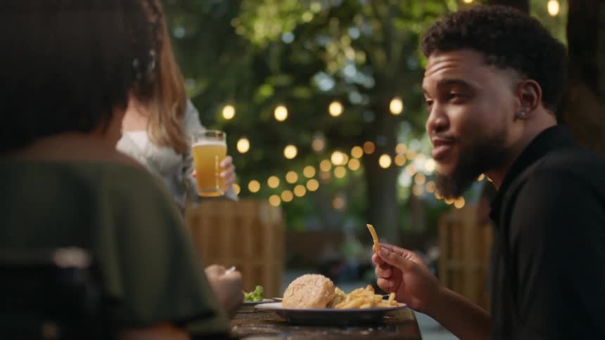 Drinks are served to a couple eating at an outdoor restaurant
