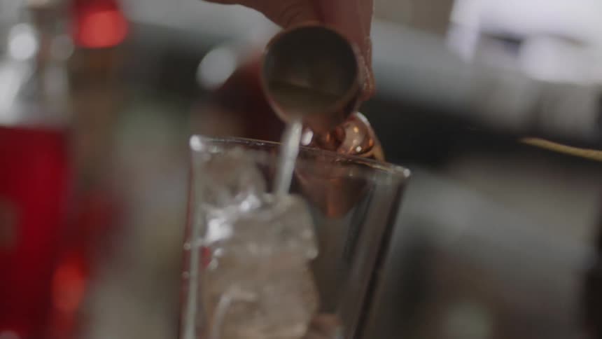 A woman mixes a drink at home