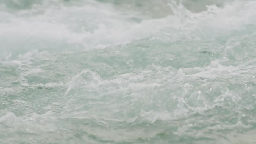 Clear water splashing around creating small waves on the surface