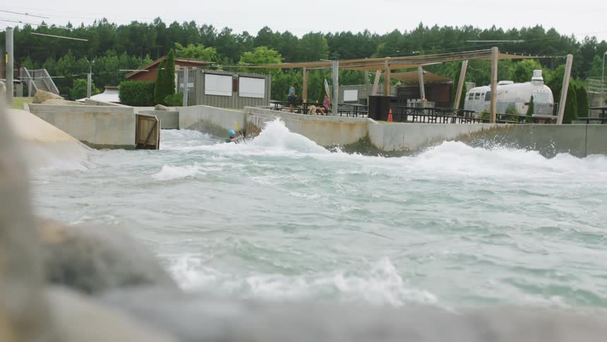 Man kayaking down a manmade river at daytime in a water park