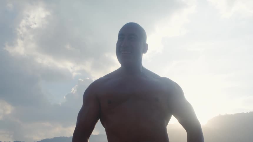 A man is standing outdoors at dusk