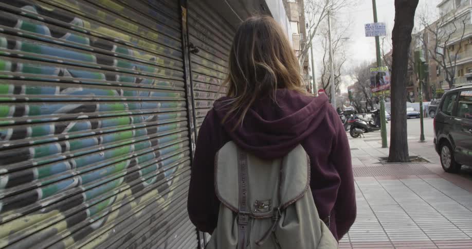 Woman walking down a street in an urban area of a city at daytime