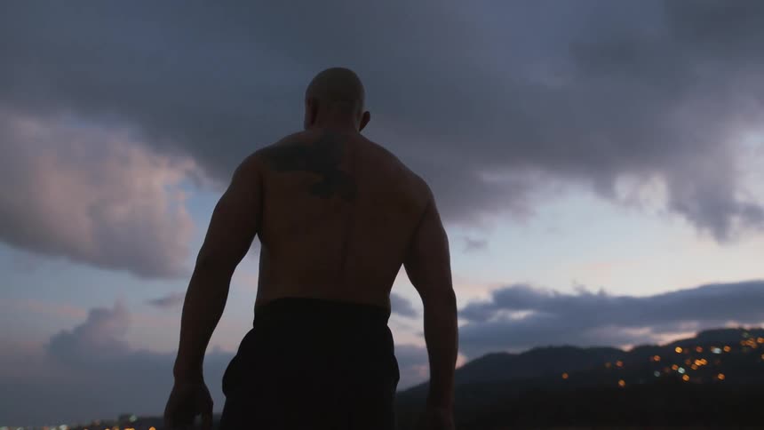 A man is walking outdoors at dusk