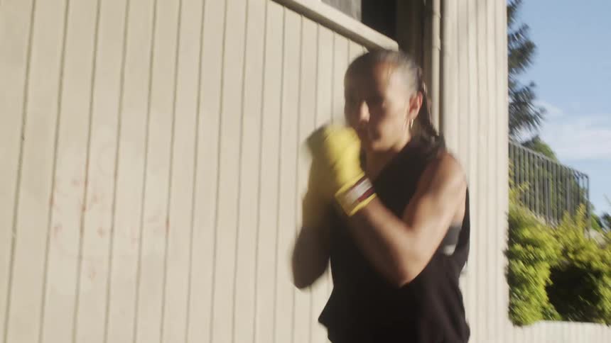 Woman boxing outside in a city